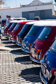View of several mini classic cars aligned on a row.
