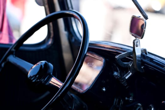 Inside view of a black classic car from the thirties.