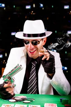 View of a gangster man playing some cards and poker, smoking a Cuban cigar.