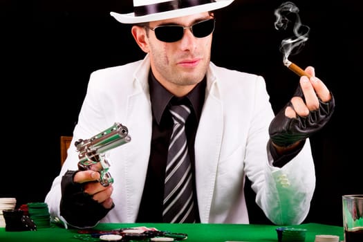 View of a gangster man playing some cards and poker, smoking a Cuban cigar.