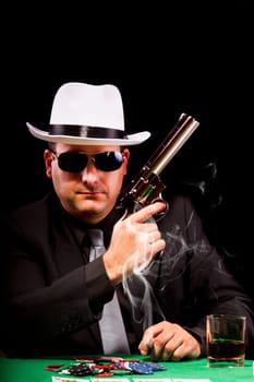View of a gangster man playing some cards and poker, smoking a Cuban cigar.