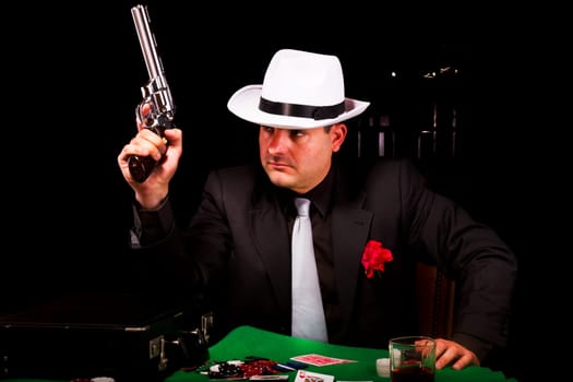 View of a dark suit gangster man holding a gun.