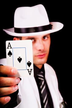 View of a white suit man with hat holding an ace card.