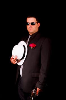 View of a dark suit gangster man holding a gun.