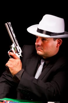 View of a dark suit gangster man holding a gun.