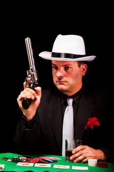 View of a dark suit gangster man holding a gun.