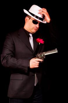 View of a dark suit gangster man holding a gun.