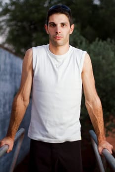 Close view of a young man doing exercise on a park.