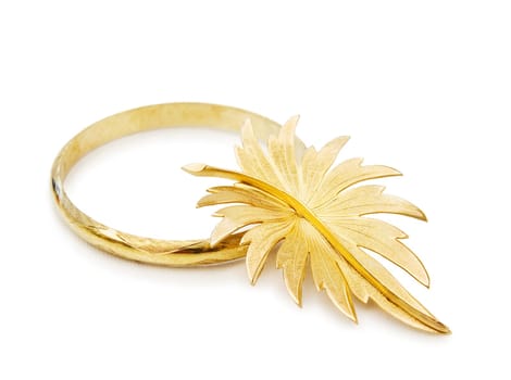 Old gold bracelet and leaf shaped brooch. Isolated on white background.