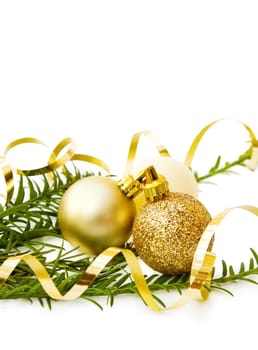 Celebrating Christmas with pine tree branch and golden baubles. Isolated on white background.