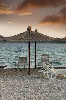 umbrellas and chairs on the beach at sunset in Croatia
