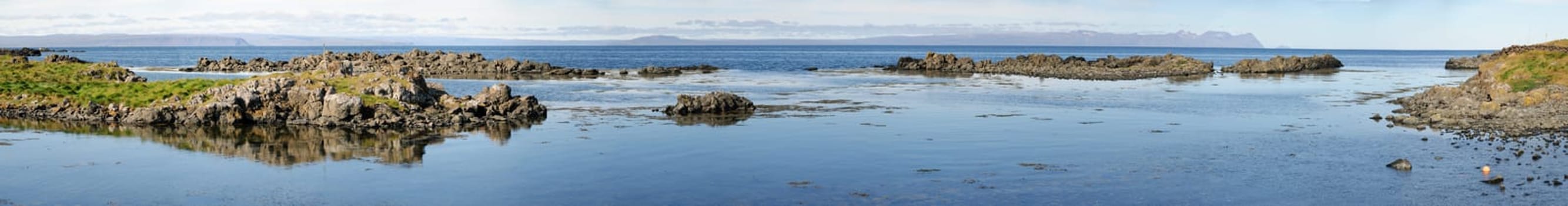 reflected in the sea cliffs of the peninsula in Iceland Vatnsness