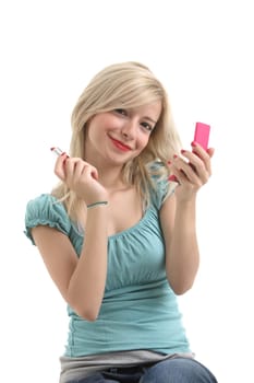 A blonde girl with red lips doing make up and smiling to camera