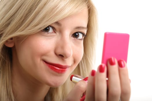 A young blonde doing make up with her small mirror.