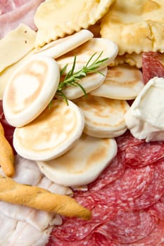 a platter of mixed cured meats, cheeses and fried dumpling
