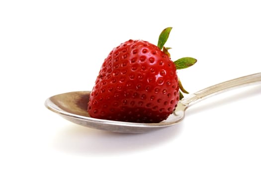 Zoomed foto of strawberry lying on small spoon