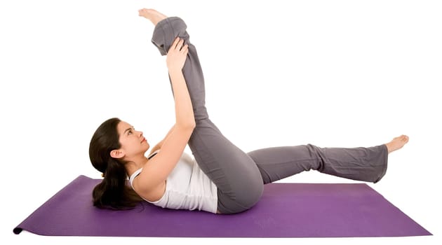 A young beautiful brunette is exercising and stretching.