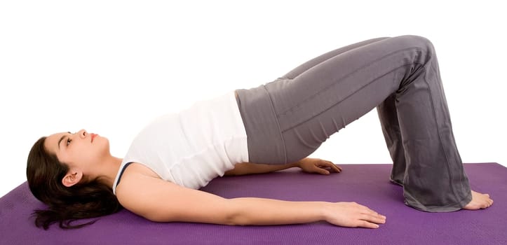 A young beautiful brunette is exercising and stretching.