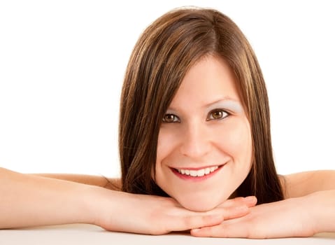 A portrait of a beautiful smiling young brunette resting her chin on her hands.