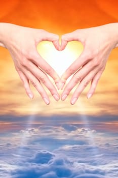 open hand in the heart of a sunset or sunrise to air on a bed of clouds