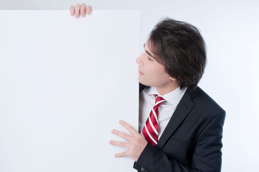 Young man appears from behind a white panel