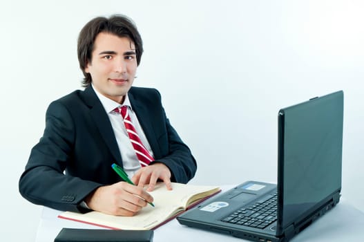 Man taking notes from a laptop on a white background