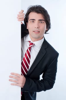 Young man appears from behind a white panel