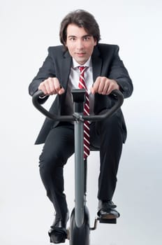 Young businessman riding a fitness bicycle isolated on white background