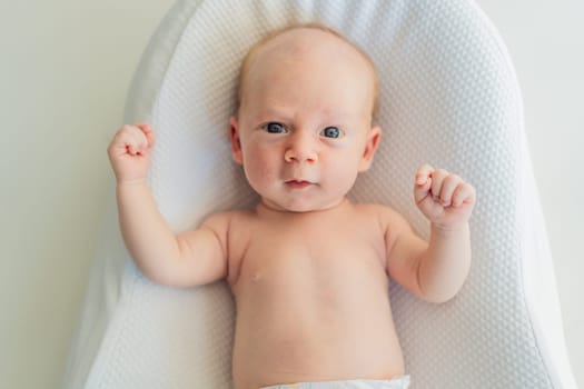 Adorable baby lying safely in a cozy infant cocoon. Comfortable and protective design for newborn care. Parenting, safety, and baby comfort concept.