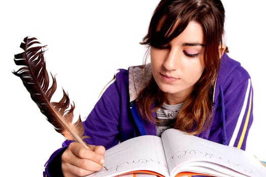 View of a teenager school girl writing on the book with a feather pen.