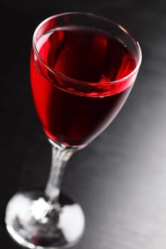 Glass of red wine on black background