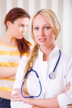 upset female patient and woman doctor - focus on doctor