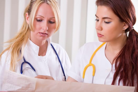 two women doctors examine a printout from an electrocardiogram