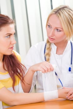 woman doctor applying hand bandage to patient