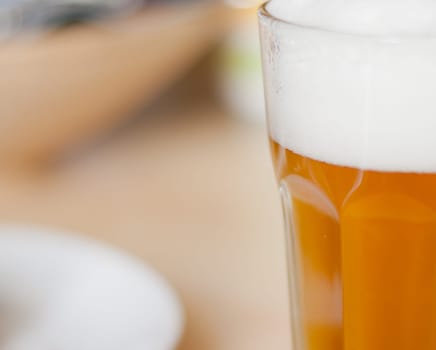 Detail of Draugt Beer in Glass on Table in Restaurant