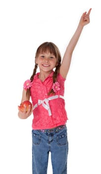 Studio photo of female child holding apple and pointing upward on white background.