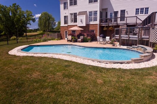Dramatic back yard swimming pool and garden behind modern single family home
