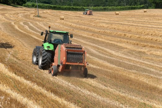 tractor with baler baling hay