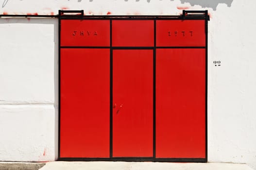 Red sliding gate in a warehouse, Portugal