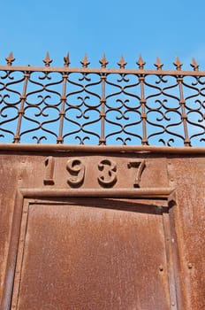 Rusty iron gate, dated 1937, in Portugal