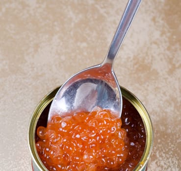 Canned salmon red caviar with spoon closeup