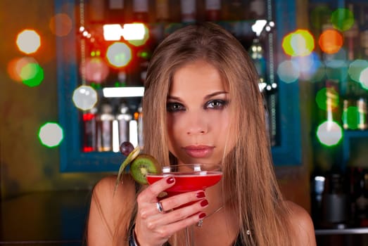Girl with cocktail on dancing people background