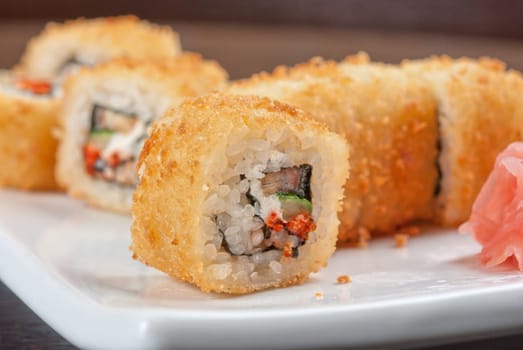 Sushi rolls made of rice, smoked eel, cream cheese and flying fish roe - tobiko caviar