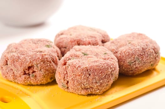 raw minced meatballs on white background