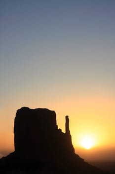 Sunrise in Monument Valley with stone formation backlit