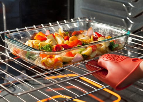 Fresh vegetables roasting in a clear dish in the oven