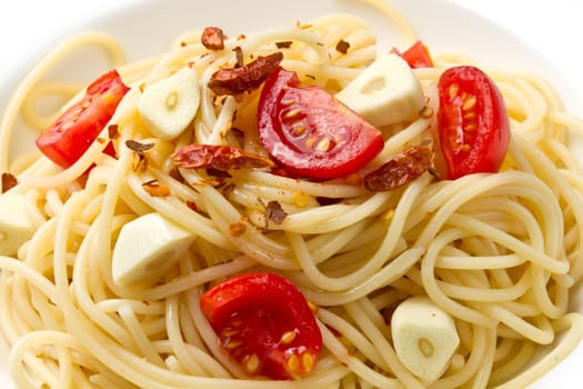 pasta garlic olive oil and red chili pepper closeup on a white dish