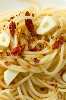 pasta garlic olive oil and red chili pepper closeup on a white dish
