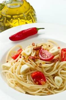 pasta garlic olive oil and red chili pepper closeup on a white dish