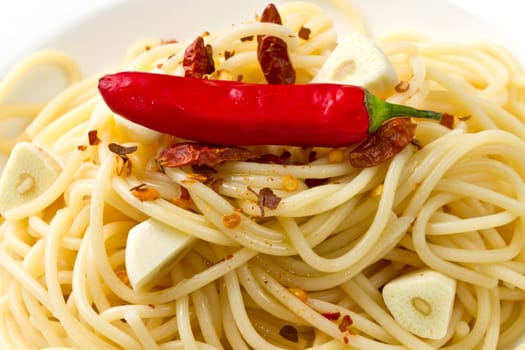 pasta garlic olive oil and red chili pepper closeup on a white dish